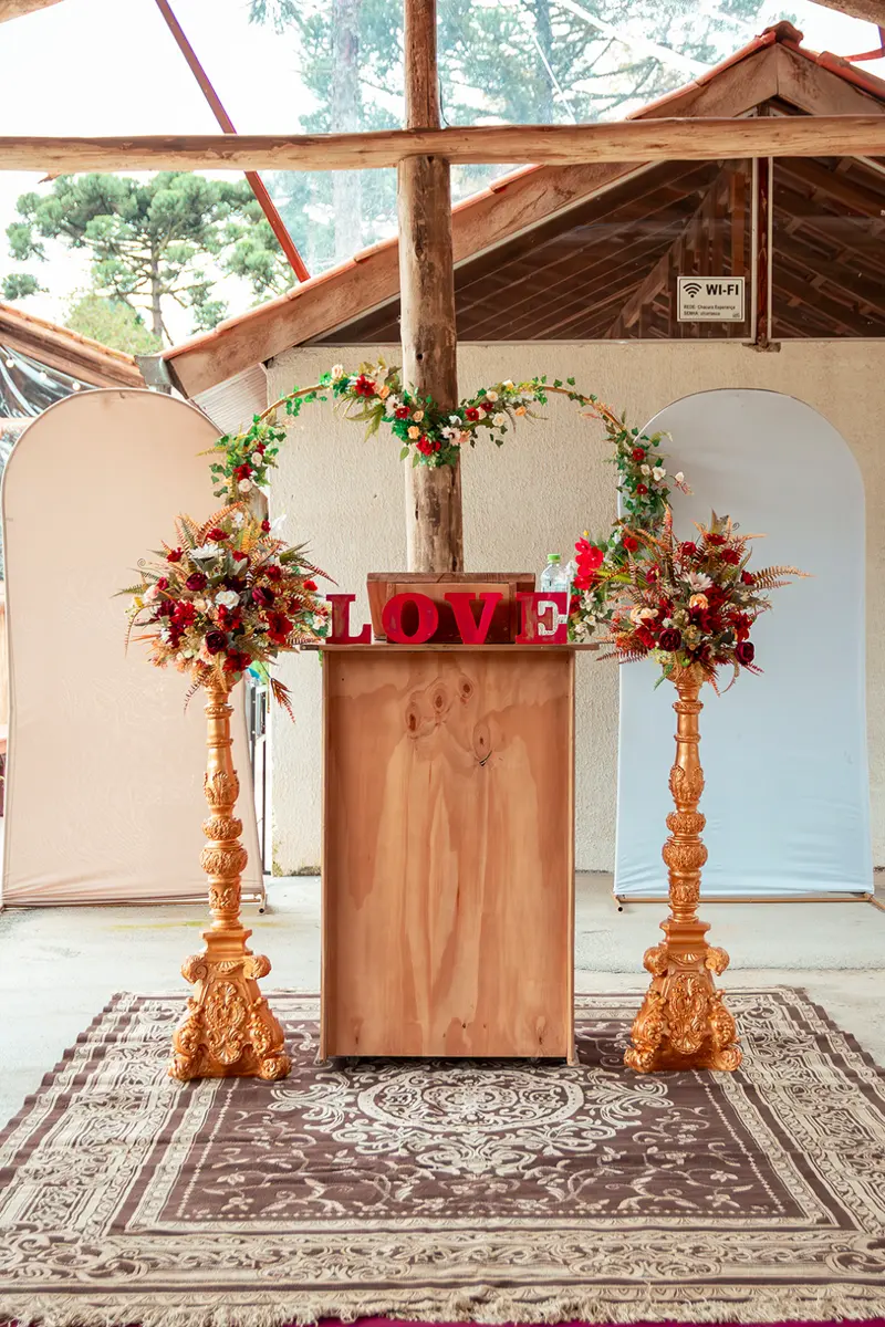 Altar com arco de flores, letreiro LOVE e tapete