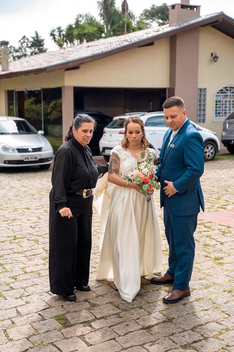 A Excellence conduz a noiva e o noivo na chegada, ajeitando o vestido